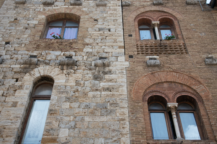 Notar los diferentes detalles arquitectonicos y usos de materiales en los edificios de San Gimignano